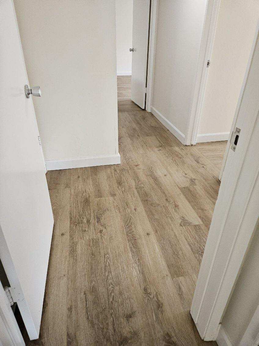 Finished LVP flooring in an Oakland rental hallway after installation