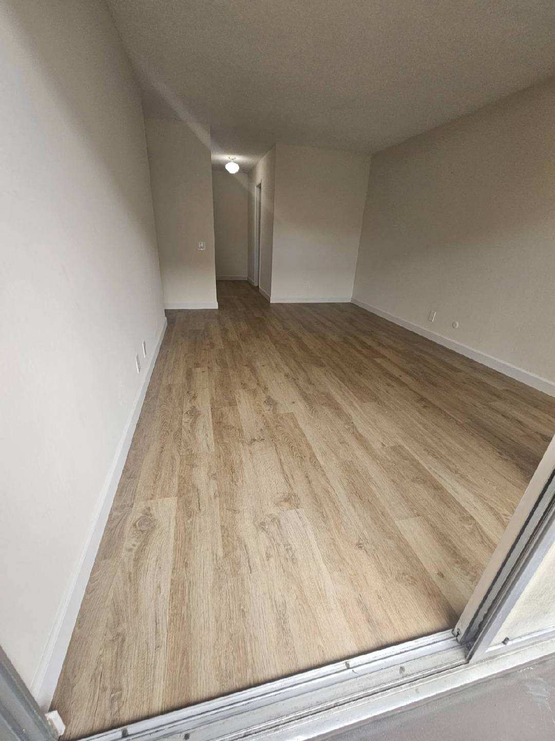 Finished LVP flooring in an Oakland rental living room after installation